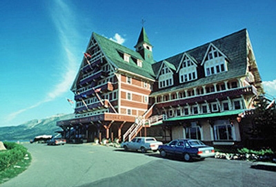 A large hotel with cars parked in front