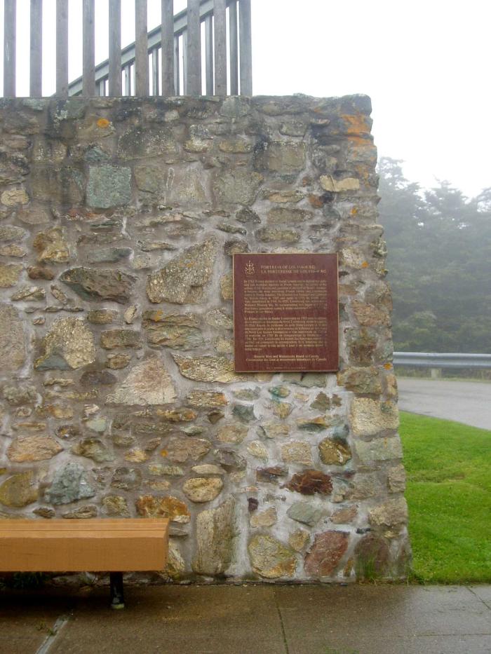Une plaque commémorative en bronze installée sur un mur de brique à l'extérieur d'un immeuble