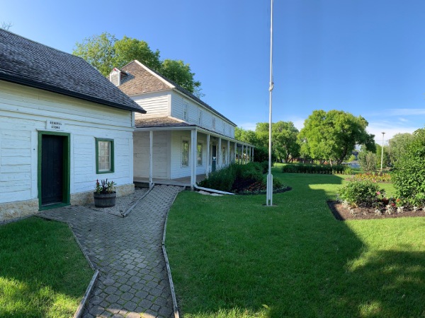 Vue latérale d'une grande maison blanche avec chemin et herbe verte