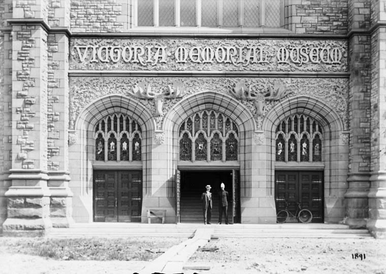 Black and white photo of the entrance to Victoria Memorial Museum, where stand two persons