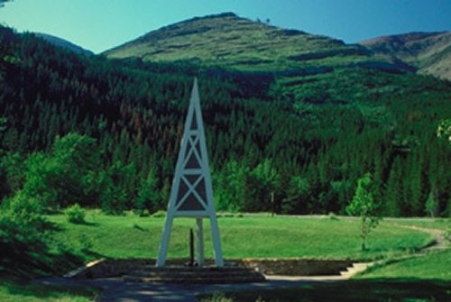 A metal tower in lush green mountains and grass