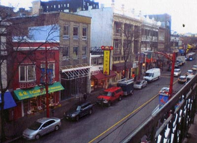 A street in a chinatown, buildings and parked cars