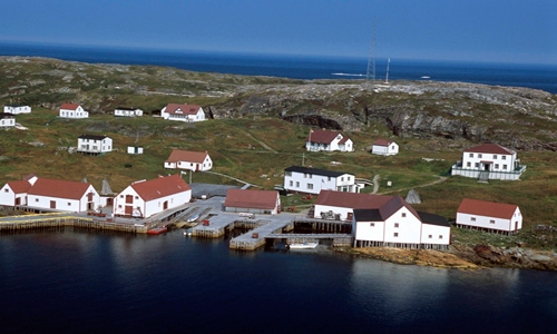 Aerial view of a coastal city with white houses with copper red rooftops