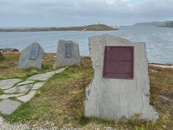 Commemorative plaque installed on a stone, in front of see view