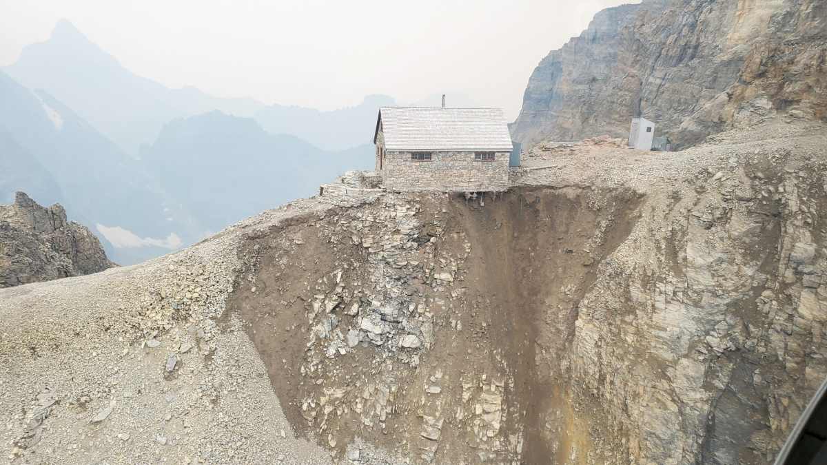 A refuge built on a mountain pass, and the ground beneath its foundations appears to be eroding.