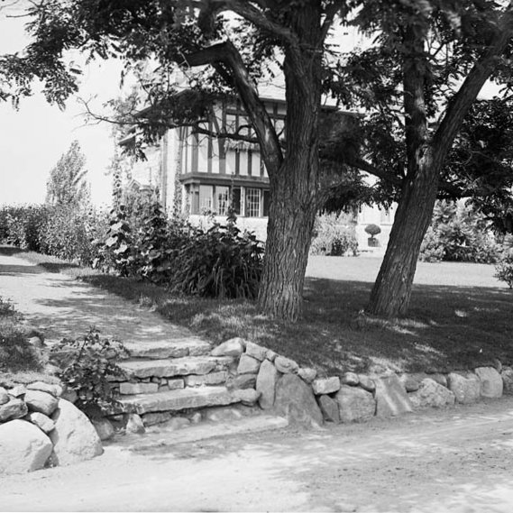 Black and white photo of a house's front yard