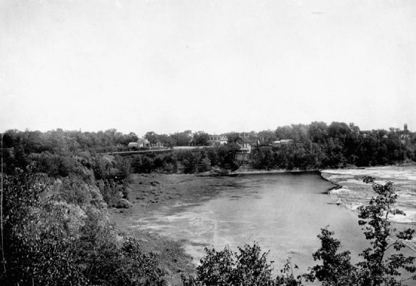 Black and white photo of a landscape showing trees and a river