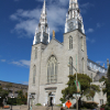 Grande église grise avec deux tours et ciel bleu en arrière-plan