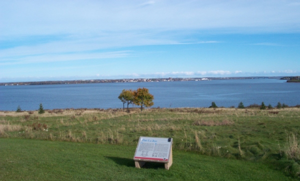 Landscape with grass, view on water and a commemorative plaque