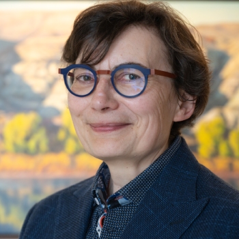 Portrait d'une femme portant des lunettes et souriant à la caméra