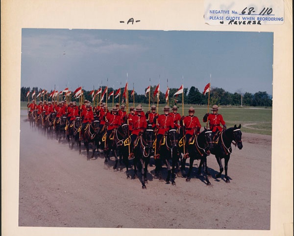 Une photo de policiers en uniforme écarlate à cheval lors d'un défilé des années 1960