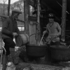 Two persons boiling maple sap at maple sugar bush, 1926
