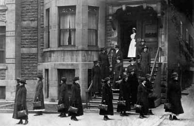 Black and white photo of a group of women in front of a building
