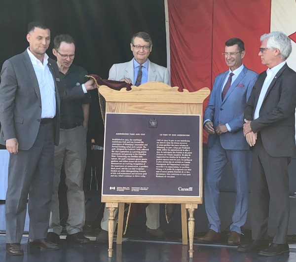 A group of men near a commemorative plaque