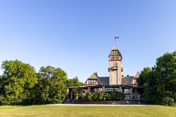 A large pavillion surrounded by trees and grass