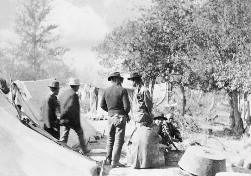 Black and white photograph of workers at their camp site