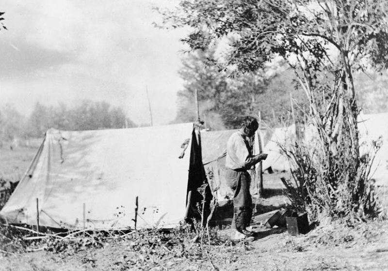 Black and white photograph of workers at their camp site