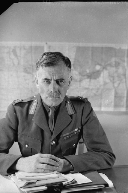 Le lieutenant-général A. G. L. McNaughton assis à un bureau en uniforme en 1942