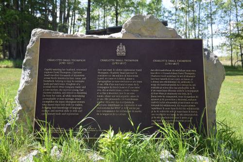 Plaque commémorative en bronze sur son socle dans l'herbe