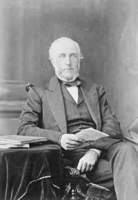 Black and white photo of the portrait of a seated man