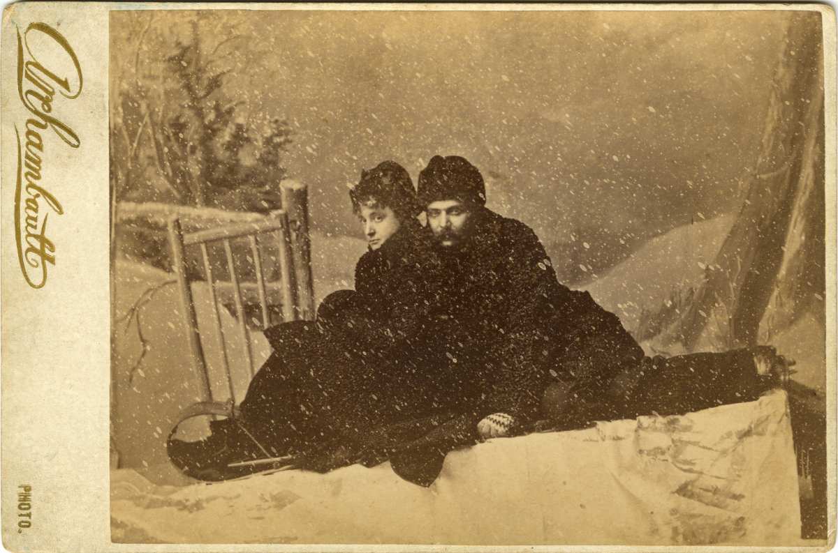 Photographie sépia d'Honoré Beaugrand et de sa femme sur une luge dans un décor hivernal