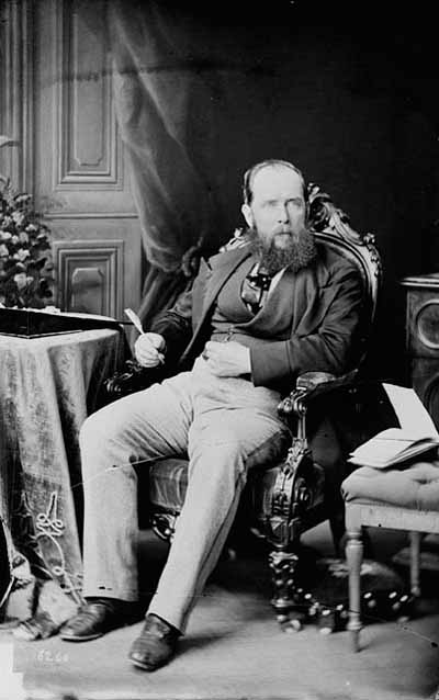 Black and white photo of a man seated on a chair
