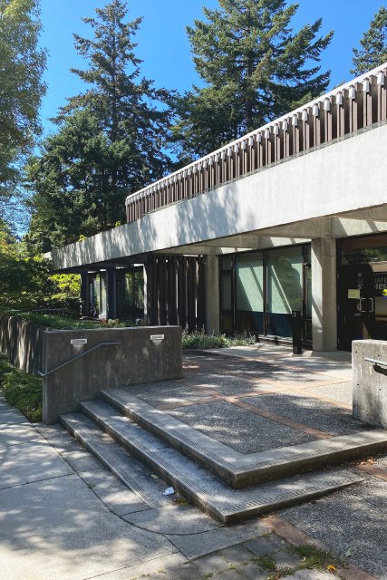 Les escaliers menant vers les portes d'un bâtiment entouré d'arbres