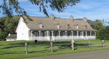 Photographie illustrant la façade principale de la maison (aujourd’hui le centre administratif) de la Petite-Ferme du cap Tourmente.