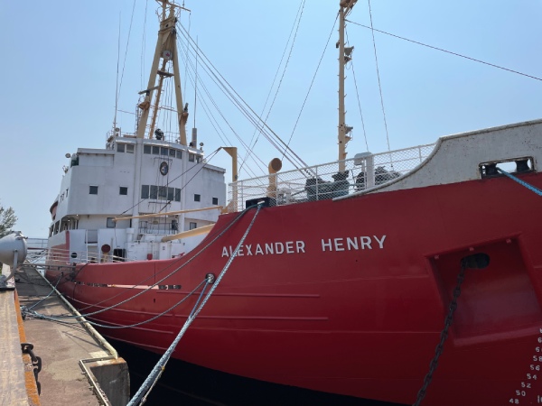 A large red and white ship next to a port