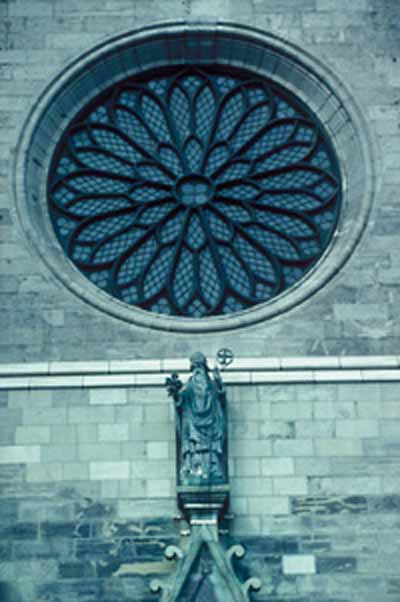 Une fenêtre ronde sur une grande église en pierres