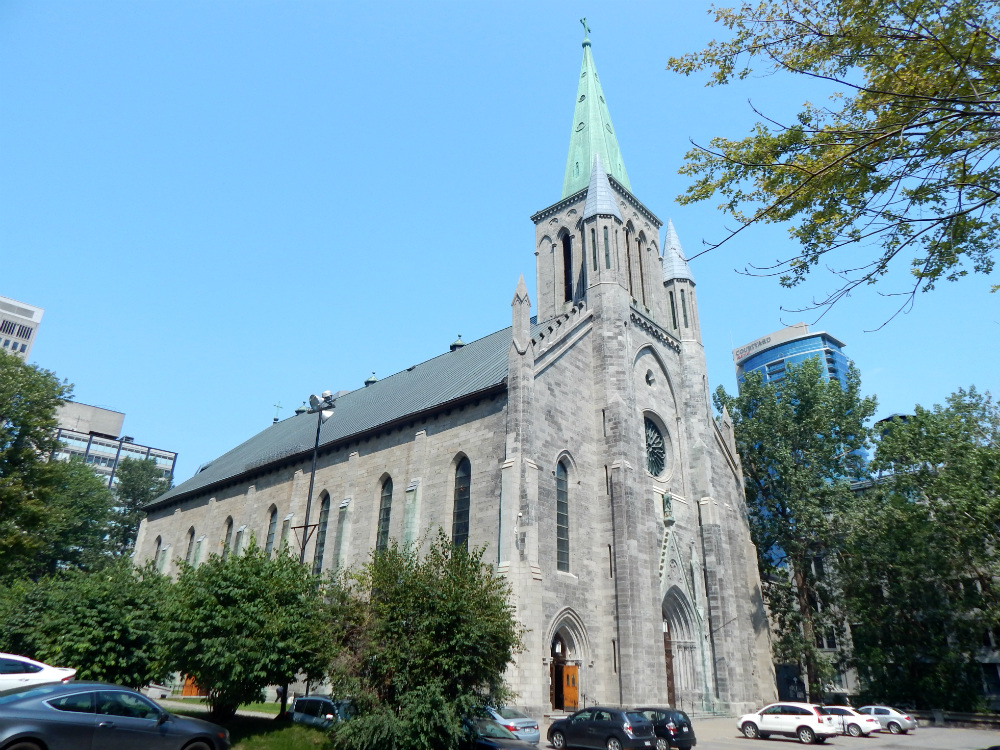 Une grande église en pierres entourée d'arbres en ville