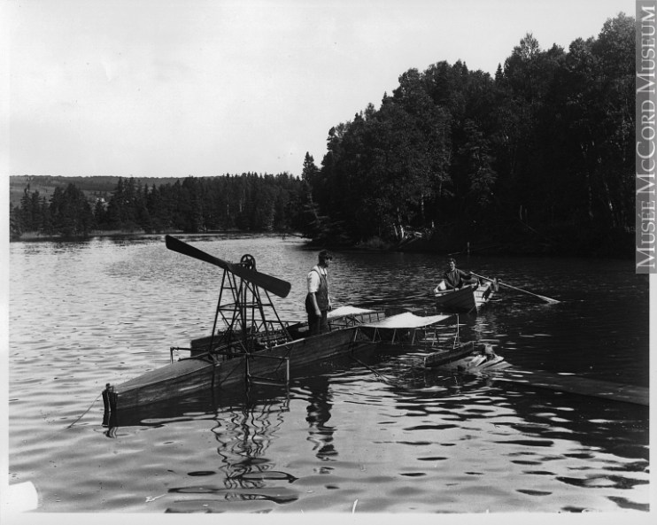 A man working on a hydroplane, on the water, circa 1915