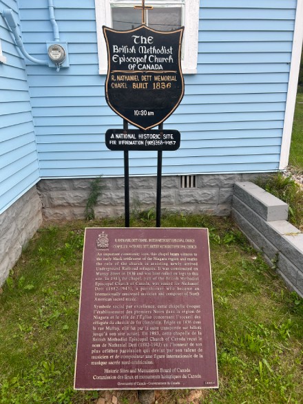 Plaque commémorative de la Commission des lieux et monuments historiques du Canada installée à l'extérieur de l'église, à gauche de l'entrée, 2023