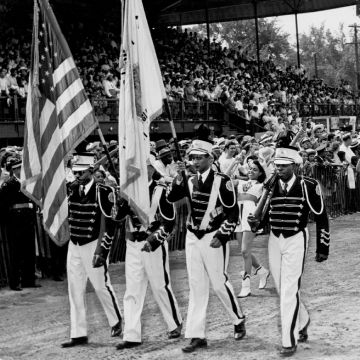 Un groupe d'hommes marchant en groupe et portant des drapeaux