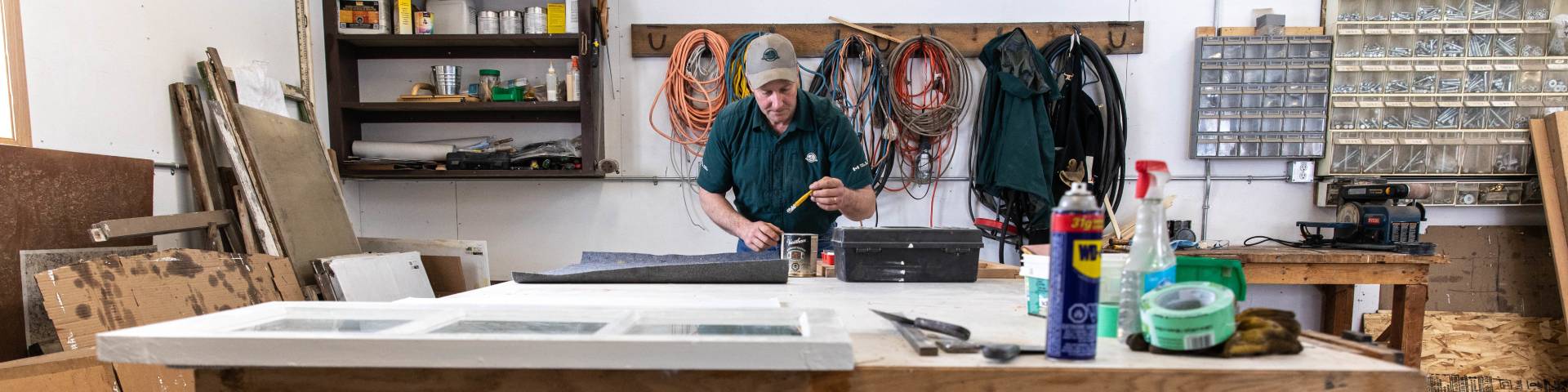 Patrick Davis fits panes of glass into a restored window frame.