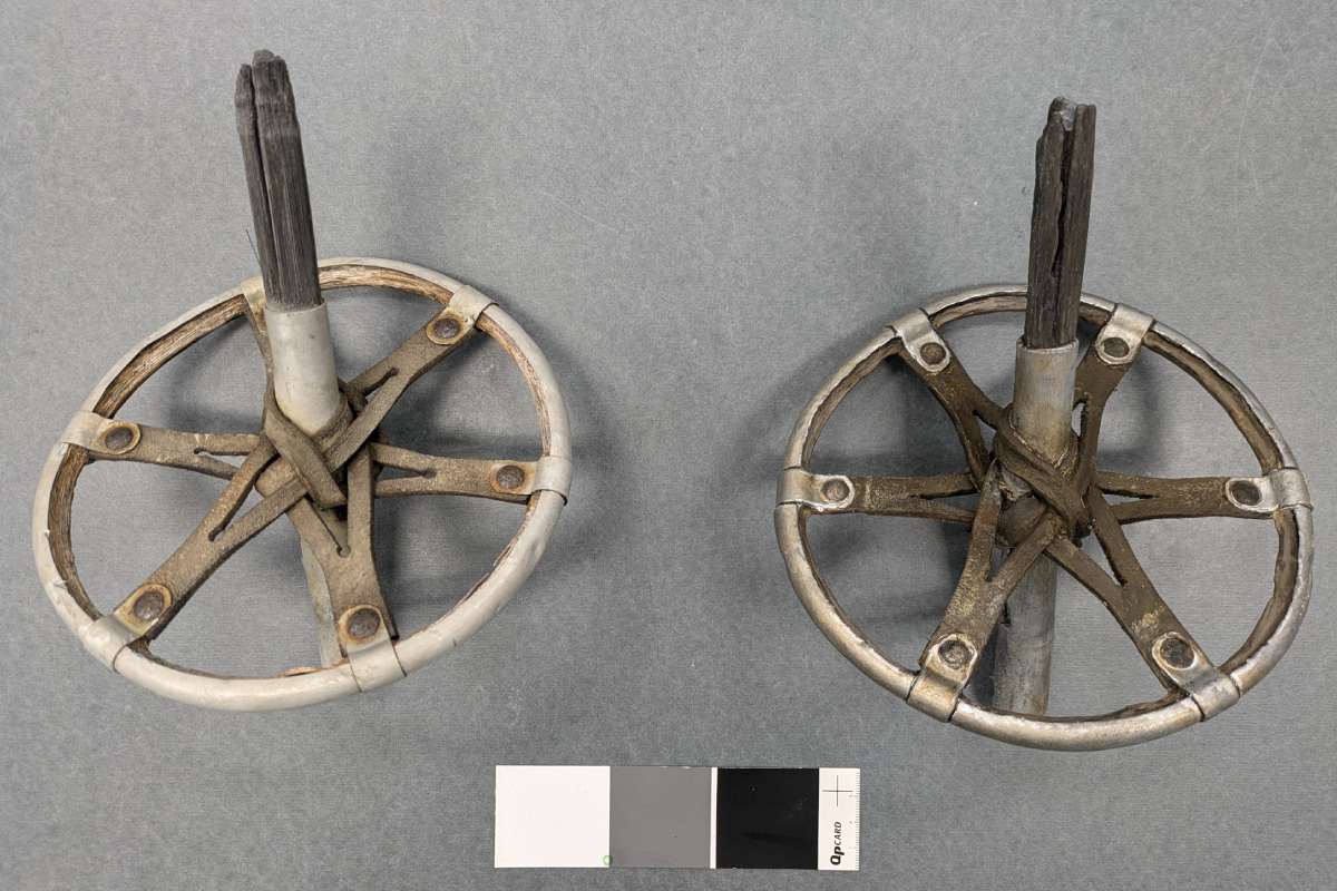 Deux paniers de bâtons de ski sont présentés côte à côte, dont l'un est une reproduction et l'autre est l'original. Les deux objets se ressemblent en forme, en couleur et en texture.