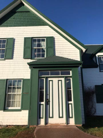 The main entrance of a historic building including two steps and a rather narrow door frame. 