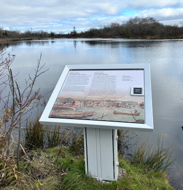 Un vue sur l'eau et un panneau d'interprétation extérieur racontant l'histoire de Baawaating, «le lieu des rapides».
