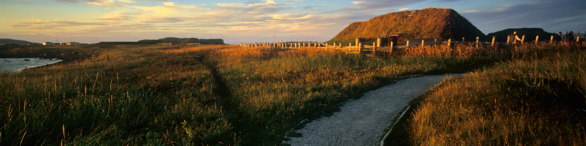 A Viking Age Norse settlement in northern Newfoundland during a sunset.