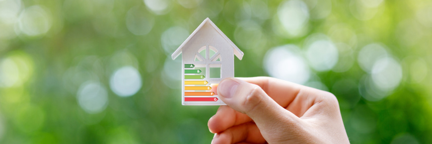 Close-up of a person’s hand holding a model of a small house