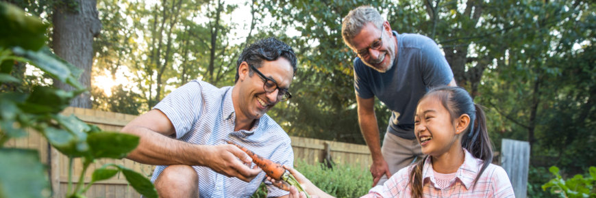 Two men and a girl in a garden.