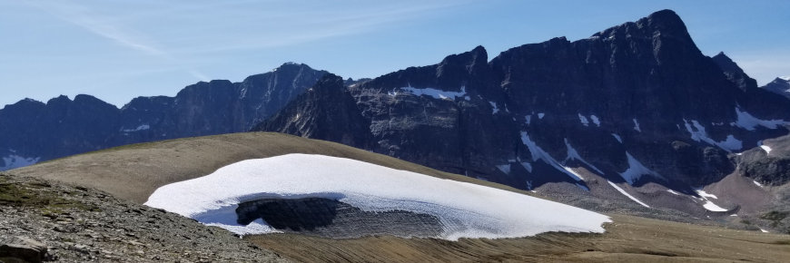 Un banc de glace à flanc de colline dans un paysage montagneux.