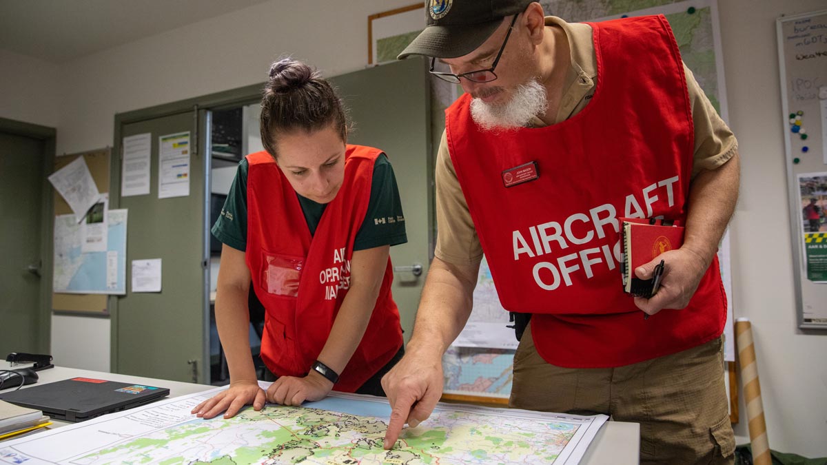 Un membre de l’équipe de gestion des incidents de Parcs Canada discute de tactiques avec un officier d’aéronef lors d’un déploiement sur les incendies de forêt en Australie en 2020.