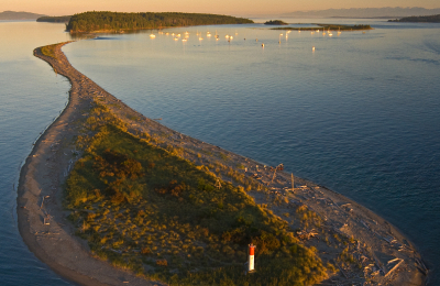 A small vegetated island spits out of a larger vegetated island.