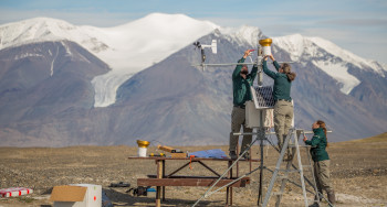 Des membres du personnel de Parcs Canada effectuent des travaux de maintenance sur une station météorologique.