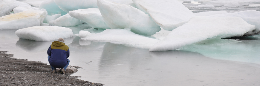Man kneeling at edge of sea ice