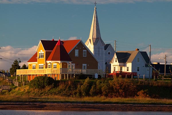 A view of Lennox Island during sunset. Three buildings are seen on the island. 