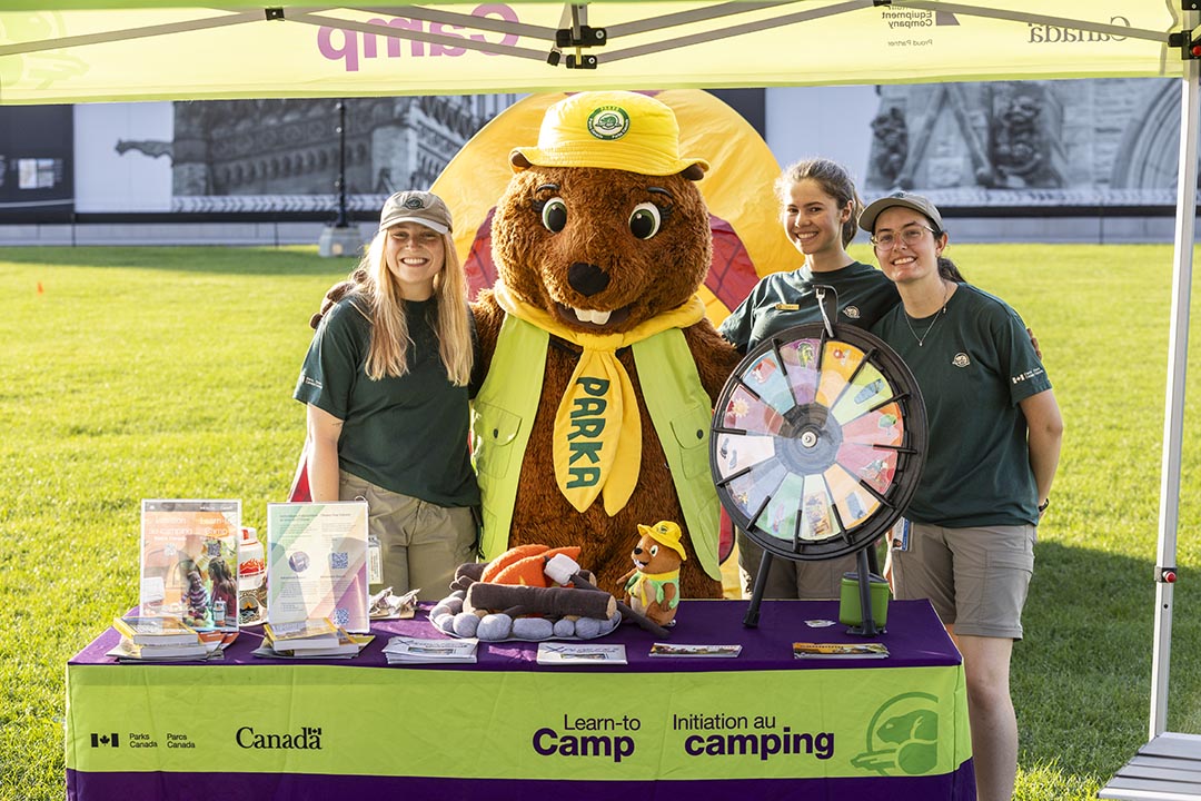 Parka, adorable mascotte de Parcs Canada, aux côtés de l'équipe d'Initiation au camping.