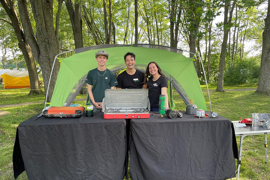 John, Kevin et Luisa présentent différents modèles de réchauds de camping.