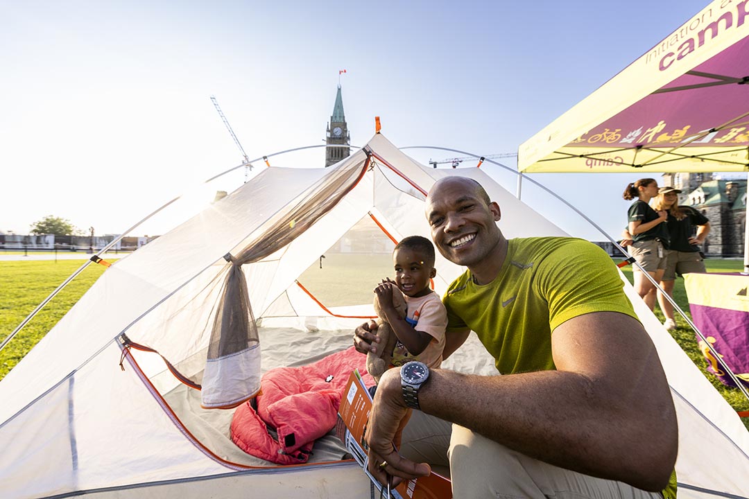 A father and son inside a camping tent.